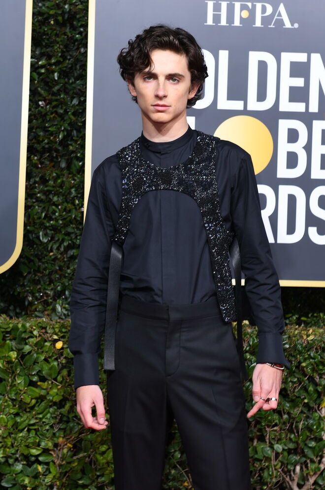 Timothée Chalamet, 2019 | O ator mais do momento brilhou na passadeira vermelha e não foi só por causa do glitter. O look preto Louis Vuitton destacou-se pelas brilhantes aplicados sobre a camisa preta e pelos acessórios da Cartier. 