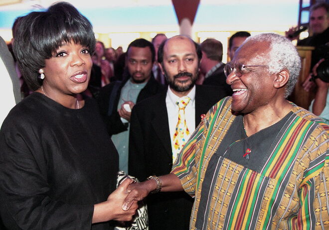 2000 | Oprah Winfrey a cumpriemntar o ex arcebispo Desmond Tutu. Winfrey conheceu Tutu durante a estreia de uma cadeia de flmes independentes, pertencente ao produtor Anant Singh, o homem que se encontra no meio de camisa branca.