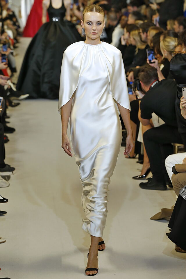 Brandon Maxwell: um design midi em cetim bege que tem uma pequena capa como adereço, um detalhe que faz toda a diferença. Para noivas que querem jogar pelo seguro e usar algo simples. O seu comprimento é ideal para mulheres mais altas.