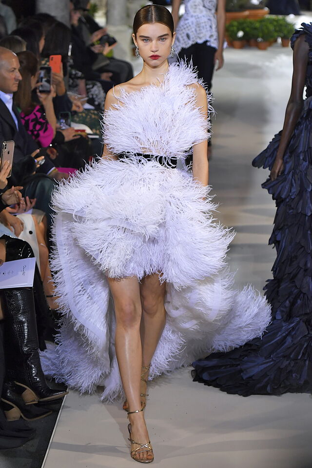 Oscar de la Renta: mais um vestido curto, desta vez assimétrico, com plumas e uma ligeira cauda. Uma escolha que tem tudo para não ser conformista, ideal para as noivas mais arrojadas, e que dirige o foco para as pernas.