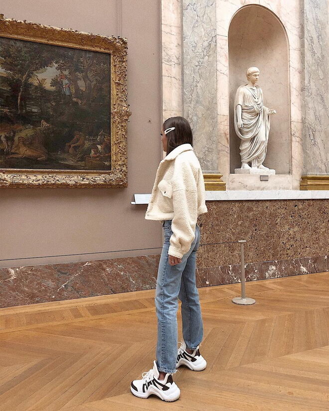 A influencer completa o seu look com uns ténios feios e grandes e jeans de corte direito e largas