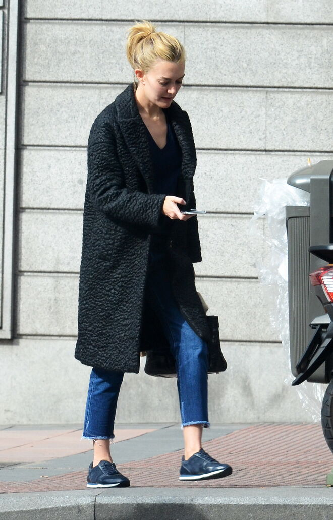 A herdeira da Zara, Marta Ortega, usa umas calças de ganga de um azul profundo, com um casaco comprido cinzento e uns ténios, um look descontraído e fácil