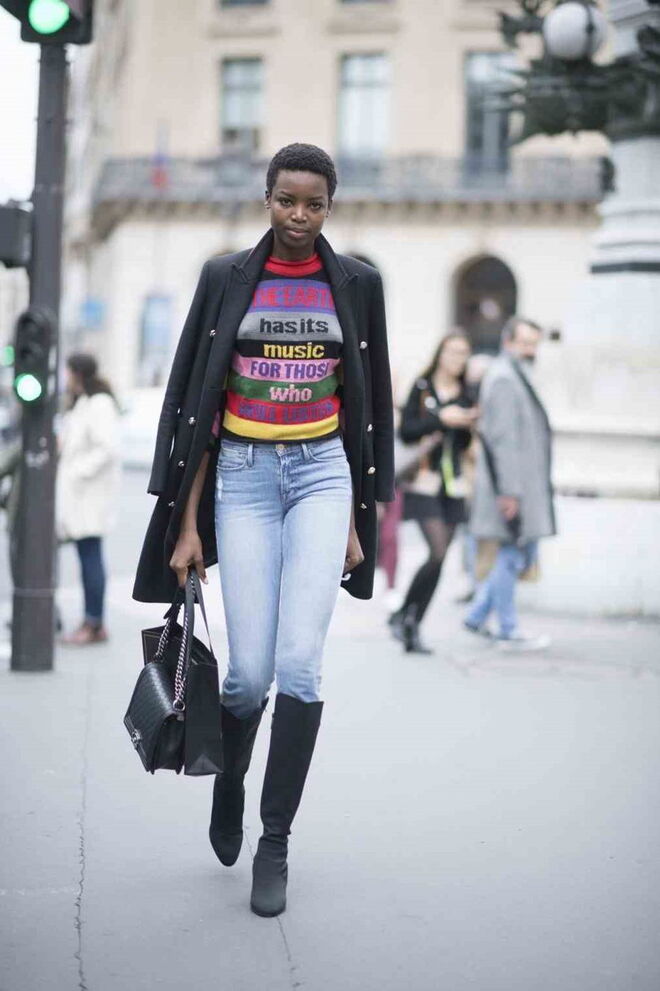 Na Semana da Moda em Paris, com umas calças de ganga clara, umas botas de cano comprido e uma camisola multi-cores