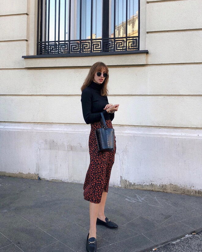 Num look mais sério, a influencer Ines Heli usa uma saia preta com detalhes encarnados