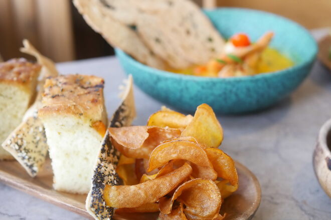 O couvert inclui pasta de alho francês, pão de folha de sementes e focaccia de banana caramelizada e ainda chips de banana
