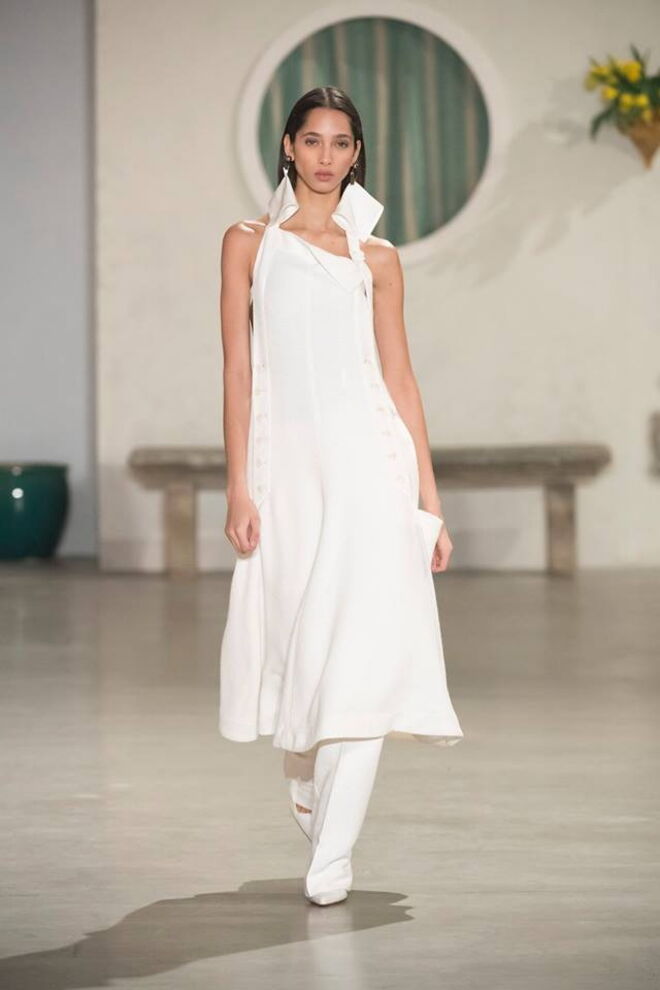 Jacquemus: um outfit totalmente branco inspirado na silhueta dos anos 70, que arrisca numa combinação de túnica longa com calças largas. Assenta na perfeição à silhueta de qualquer noiva, sem nunca perder a elegância.