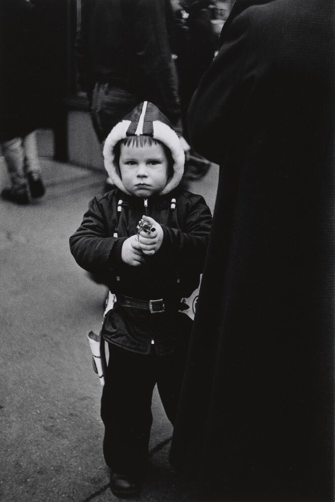 Kid in a hooded jacket aiming a gun, New York City, 1957. Diane Airbus.