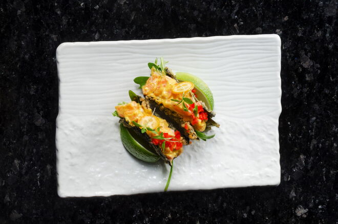 Taquitos, duas unidades com salmão, nori, molho de Aji Amarillo, mix de folhas e guacamole 