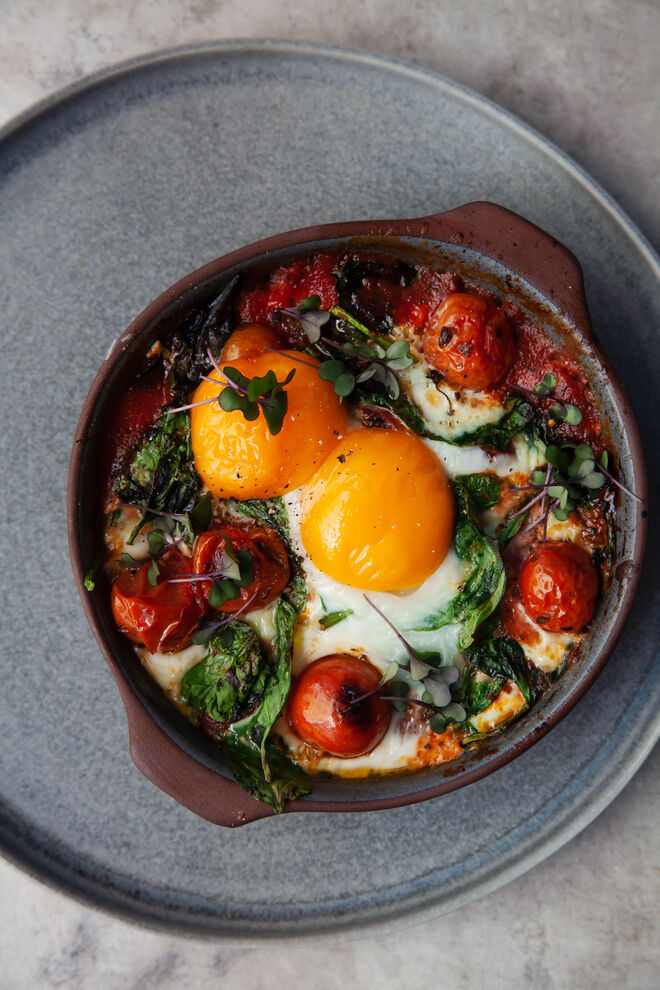 Os ovos quentes com tomate e espinafres fazer a transição perfeita entre o pequeno-almoço e o almoço.