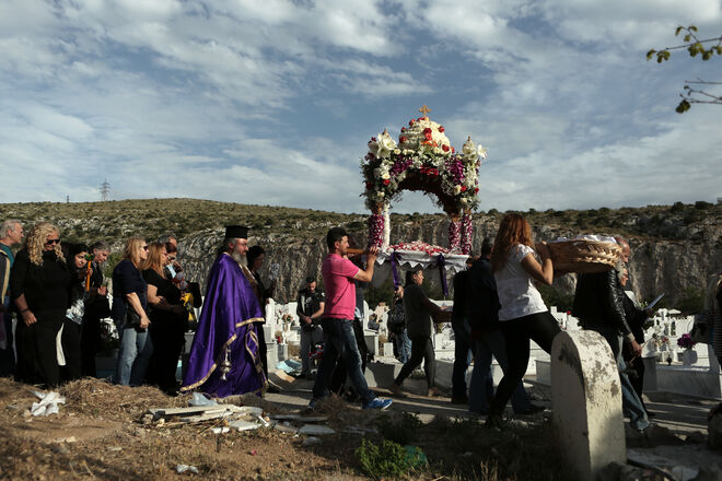Padres e cristãos ortodoxos participam na procissão do Epitaph no cemitério de Nikea, numa Sexta-feira Santa, em Atenas (Grécia).
