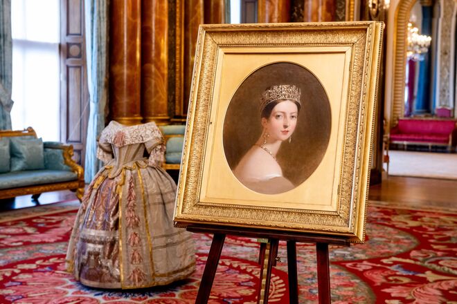 Um retrato da rainha Victoria, por Thomas Sully e atrás o figurino da rainha Victoria para o Baile Stuart, na exposição Queen Victoria's Palace, no Palácio de Buckingham em 2019.