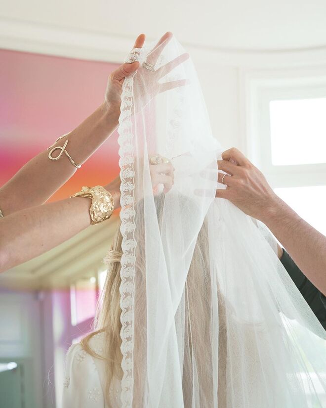 O véu foi feito em tule de seda e organza e bordado com as iniciais E e C
