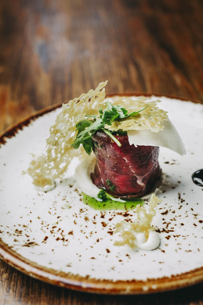 Rolo de carpaccio de novilho com rúcula, redução de balsâmico e lascas de parmesão
