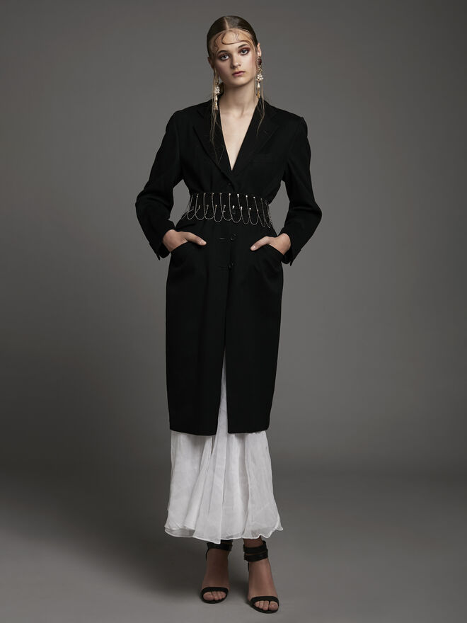 Stylist: Clara Cardoso de Oliveira | Modelo: Gabriela Gorenco, Karacter Agency | Tema: V de Vitória | Sobretudo, vestido cinto e sandálias Peris Costumes; Brincos Outra Face da Lua