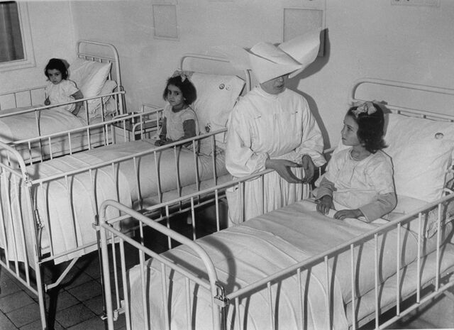 Enfermeira cuida de três crianças com tifo no Vatican Hospital of Holy Child, em 1944
