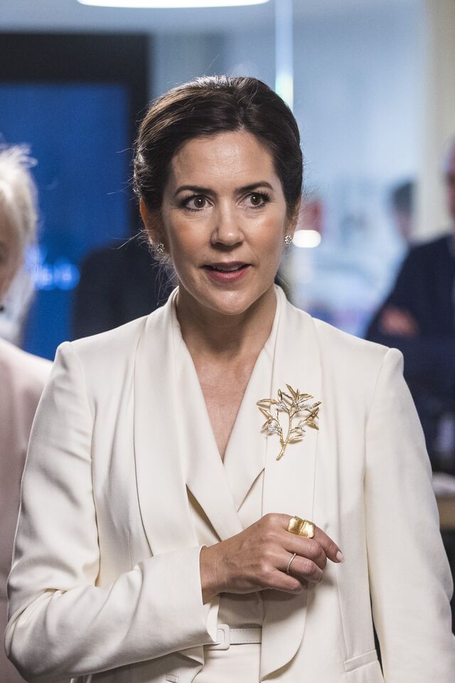 A princesa Mary da Dinamarca com uma pregadeira de inspiração floral dourada, durante uma viagem oficial à Suécia.