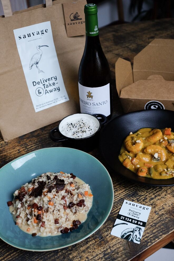 Sauvage | Repleto de opções gastronómicas deliciosas, com sabor português e um twist internacional, o Sauvage disponibiliza os serviços de take-away e entregas ao domicílio. Entre as apetecíveis sugestões, destacam-se o risoto de pato com chouriço crocante e queijo parmesão (15€), os Secretos à Lagareiro, que incluem batata a murro e grelos salteados e foram idealizados para toda a família - é possível selecionar doses para quatro (42€), seis (58€) ou oito (72€) pessoas. Existem ainda três menus disponíveis o Monstera (31€) que inclui um risoto, um pad thai e uma mousse de chocolate; o Lótus (32€) que para além dos ovos Sauvage – que são panados e têm lascas de batata, crumble de farinheira e molho aveludado de ervas – inclui caril de camarão e chamuças de coelho; e por fim o menu Ave do Paraíso (32€) que inclui nigiri de pato fumado, o prato vegetariano nasigoreng de legumes e atum fresco.   Em pedidos superiores a 30€, é possível usufruir da oferta de uma garrafa de vinho tinto, branco ou rosé, bem como de taxa de entrega gratuita no concelho de Lisboa. Outros concelhos como Cascais, Oeiras, Odivelas, Loures e Almada, são também abrangidos pelo serviço e têm um custo de 7€.
O Sauvage, localizado na Av. António Serpa, 9A, tem serviço disponível de take-away e entregas ao domicílio - Uber Eats, o Take-Away, o NoMenu e brevemente também o Zomato Take Away e a Glovo -  e está aberto de terça-feira a domingo, das 12h00 às 22h20, em horário ininterrupto.