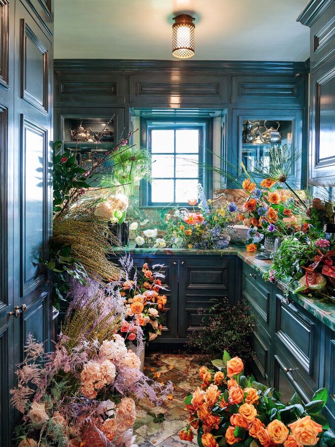 A antiga cozinha do mordomo é o espaço de reflexão da decoradora, com vista para os eucaliptos no exterior. O espaço está cheio de flores em preparação para uma festa. Do livro Evocative Style, de Kelly Wearstler (Rizzoli).