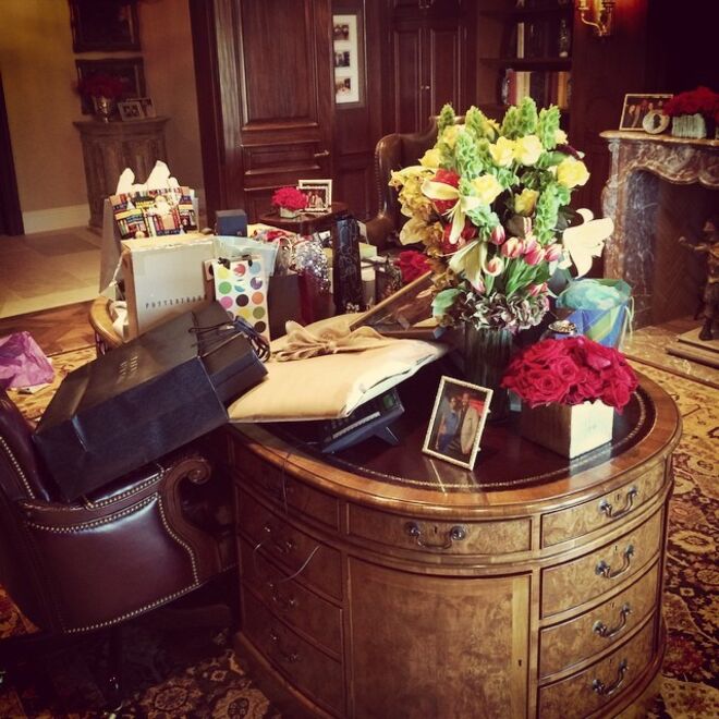 O escritório da casa com paredes de painéis de madeira, cadeiras em pele e uma opulenta lareira em mármore