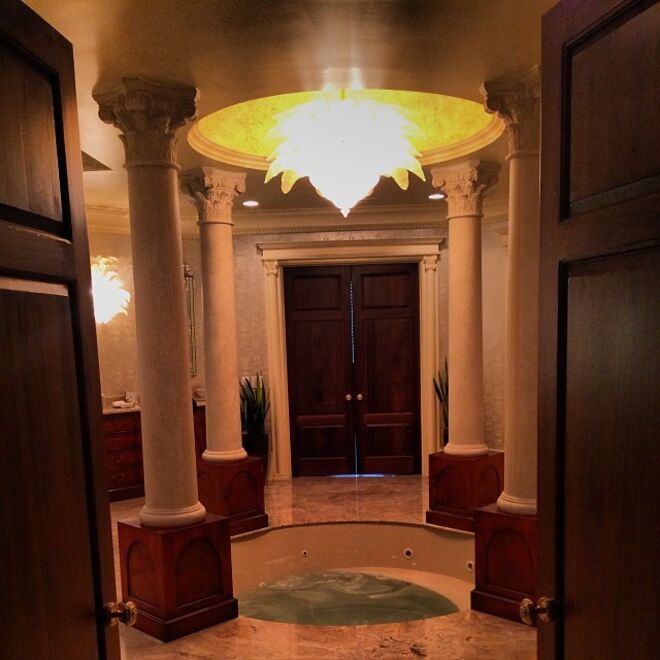 A casa de banho com uma enorme banheira de imersão e mármore de parede a parede