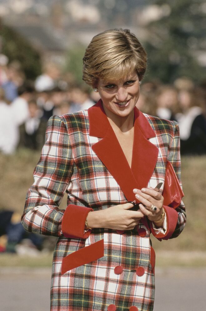 Numa visita a Cullompton, Devon, em 1990. O casaco e o vestido são criações de Catherine Walker.