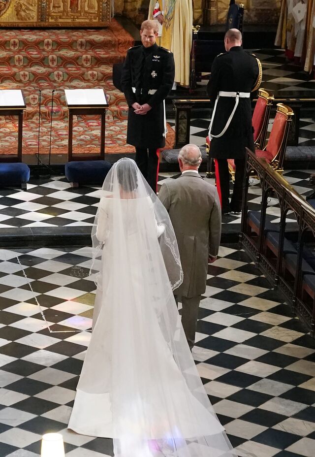 Carlos acompanha Meghan até ao altar onde Harry a aguarda.