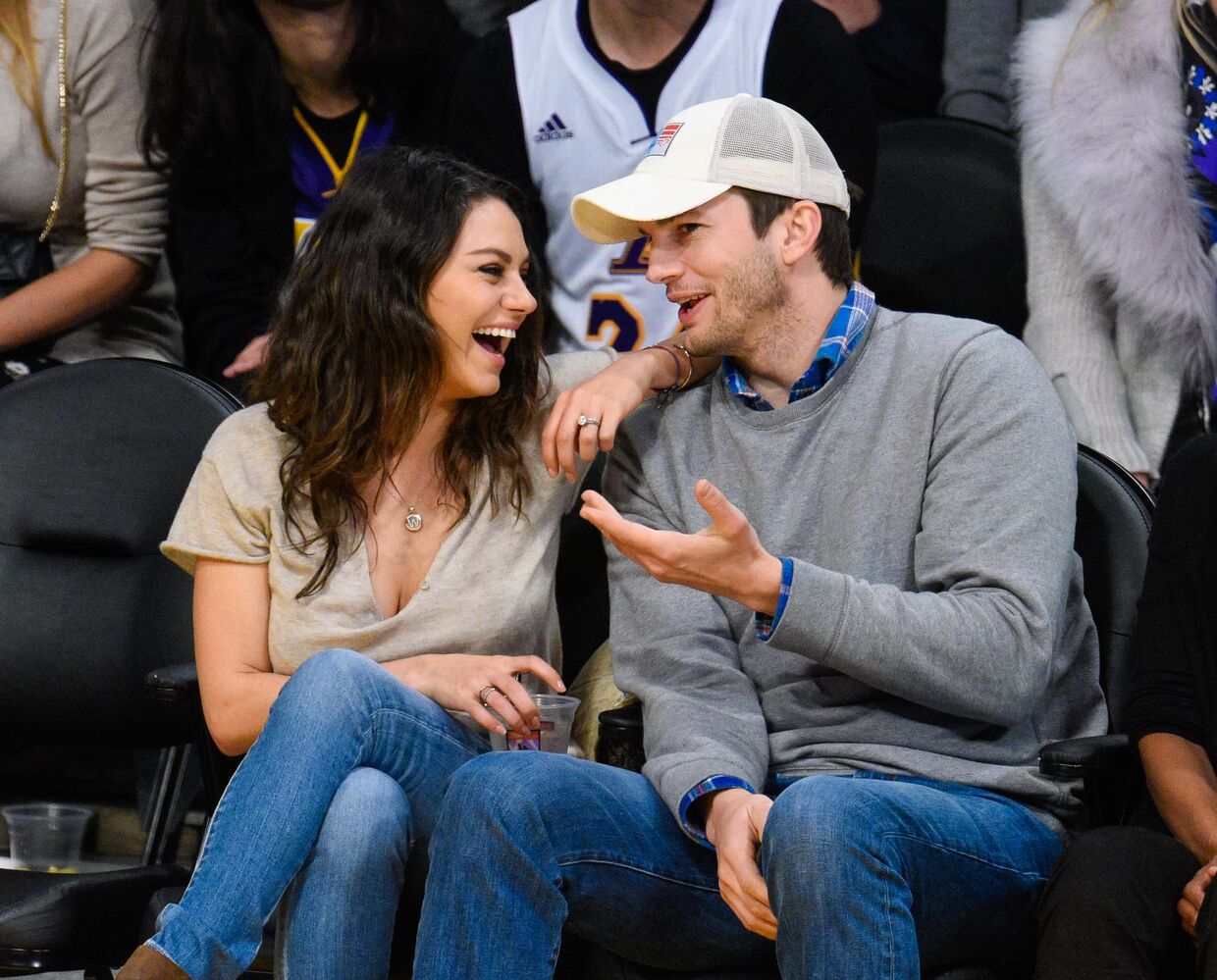 Mila Kunis e Ashton Kutcher assistem a um jogo de basquetebol em 2014.