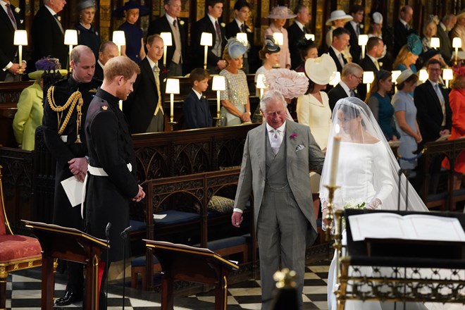 Príncipe Carlos a levar Meghan Markle ao altar durante a cerimónia de casamento com Harry.