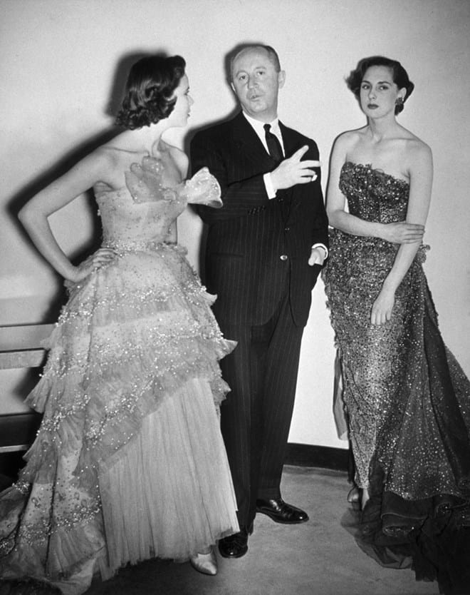 Christian Dior com duas modelos a usar os seus vestidos (1949).