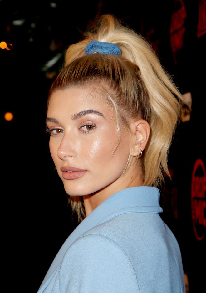 Hailey Bieber gosta de fazer apanhados, como este, bem no alto da cabeça, que lhe dá um ar ainda mais novo.