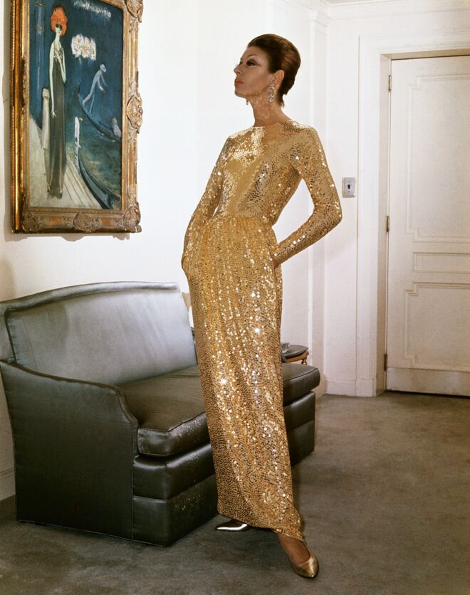 Uma modelo veste um vestido bordado a lantejoulas dourado de Norman Norell da sua colecção de Outono/Inverno, 1963. 