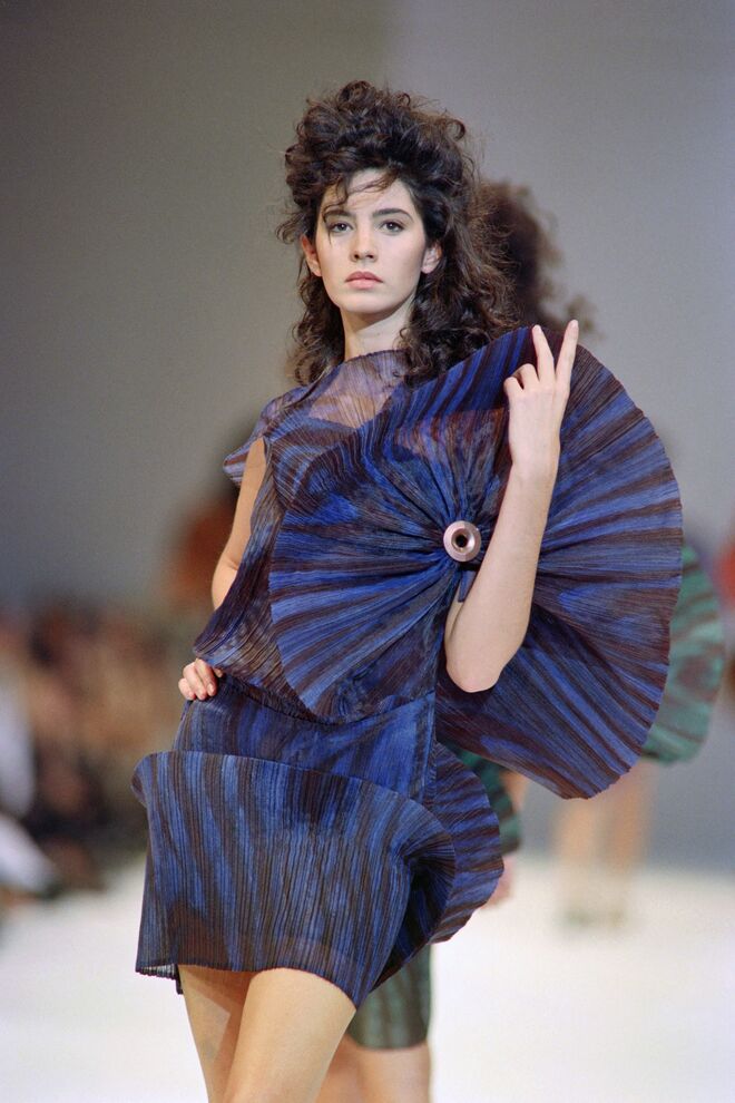 Uma modelo veste um vestido plissado em poliéster como parte da coleção Pronto-a-Vestir Primavera/Verão 1990 de Issey Miyake, Paris