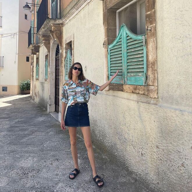 Em modo férias, Alexa Chung optou por um conjunto casual e fresco - saia de ganga, sandálias confortáveis e camisa de manga curta 