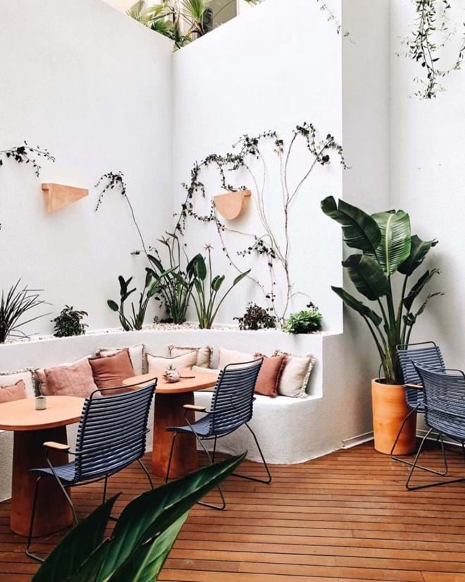 A decoração do pátio destaca-se pelos tons de terracota, mobiliário estilo vintage e pelo bonito jardim suspenso.