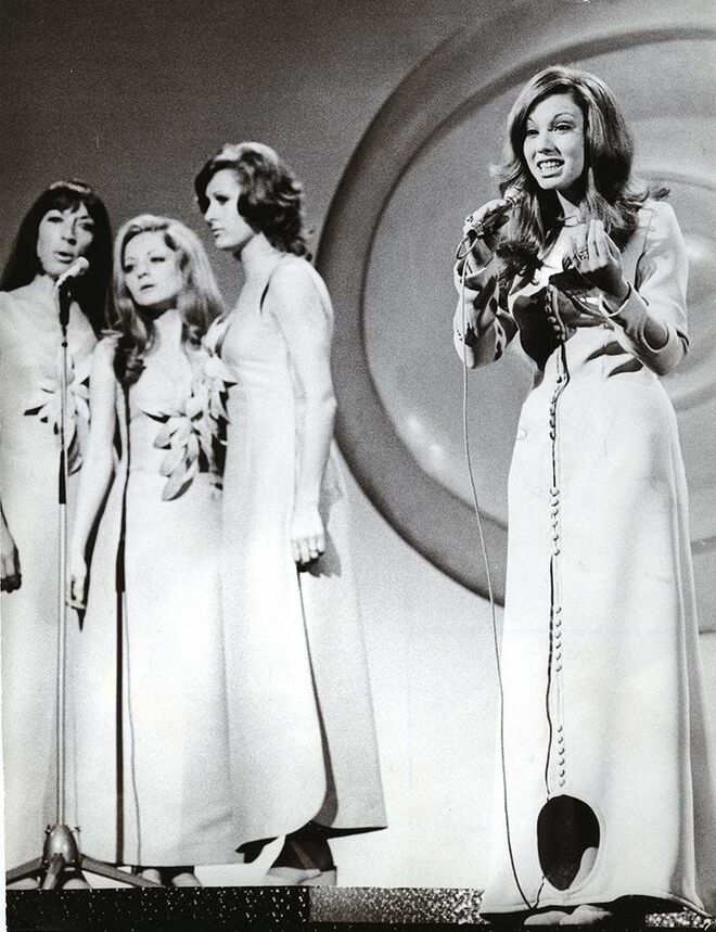 Foi a representante espanhola na capital irlandesa em 1971 com o tema "In a new world". A cantora usou um magnífico fato que Antonio Nieto desenhou para ela: em turquesa, justo, com botões medievais, buracos nas mangas e outra maior na ponta da saia que deu à criação o apelido de 'The Cat Flap'.