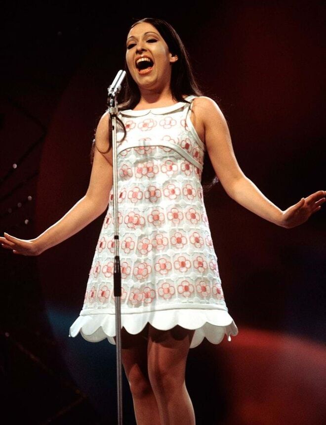 Defendeu o "La, la, la" em Londres com mais graça do que ninguém, usando um minivestido Courrèges branco com margaridas rosa bordadas.