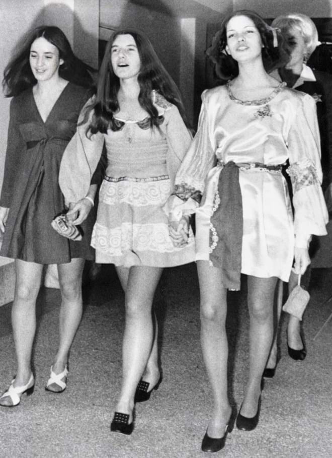 Susan Atkins, Patricia Krenwinkel e Leslie Van Houten caminham lado a lado ao longo de um corredor em direção à sala de audiências onde o juiz William Keene marcou para 20 de abril a data do seu julgamento com o outro suspeito, Charles Manson.