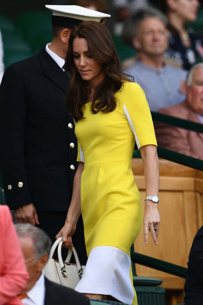 2016. Kate com um muito elegante vestido bicolor. Depois dos primeiros anos, em que o branco era a cor que a princesa privilegiava, o amarelo, o verde e o azul começam a aparecer com mais frequência nos seus looks.