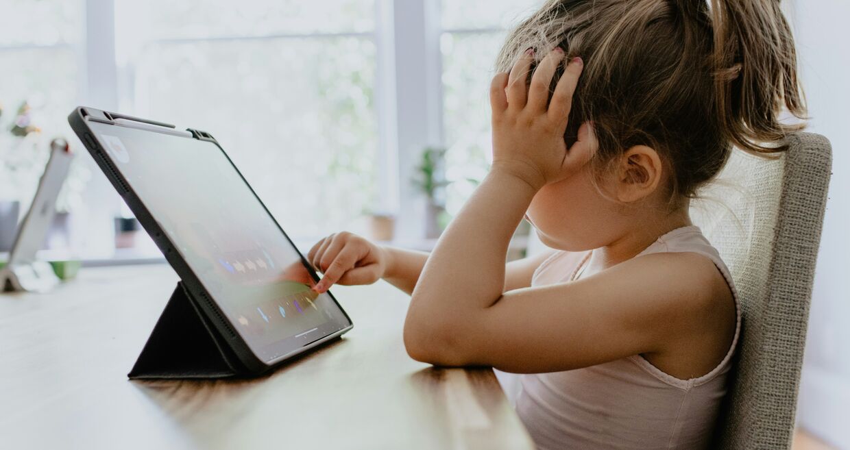 Criança usa tablet, lidando com problemas socioemocionais