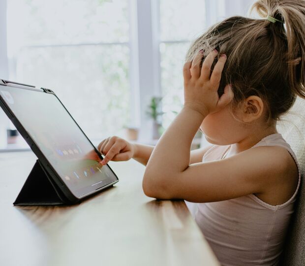 Criança usa tablet, lidando com problemas socioemocionais