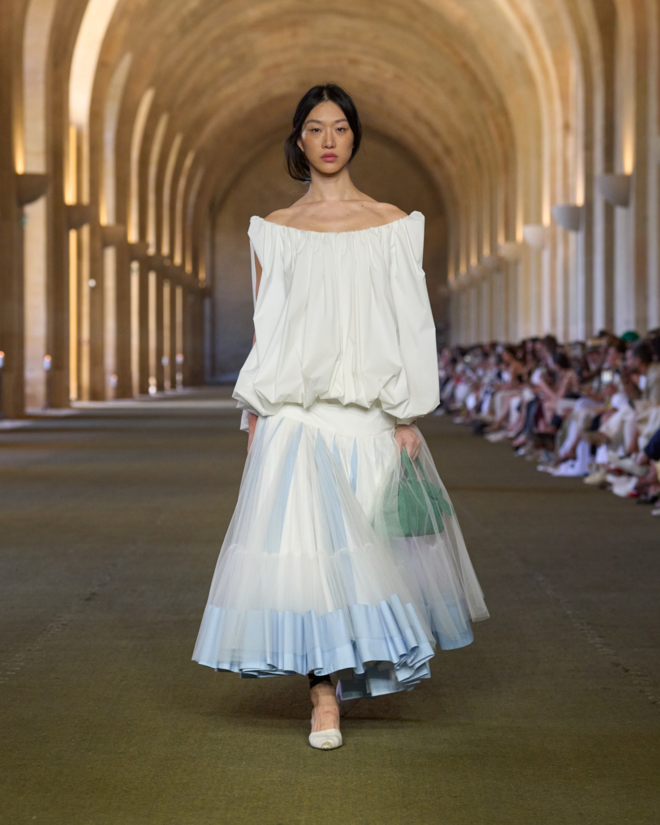 Desfile de Jacquemus em Versailles apresenta nova coleção com modelos e peças únicas.
