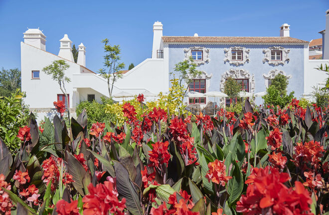 O hotel abraça o seu próprio jardim, outro amor de Louboutin. É uma alegria exuberante de flores, canas vermelhas, como é natural, plantadas propositadamente para um efeito dramático