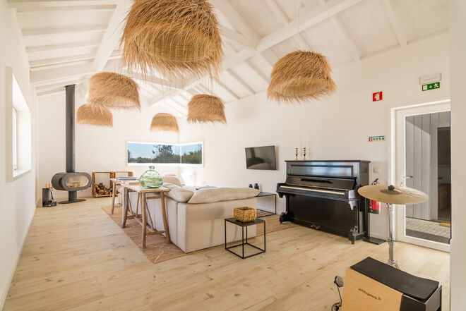 A sala alberga um piano e madeiras rústicas
