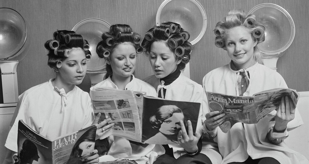 Mulheres leem revistas num salão de beleza nos anos 70