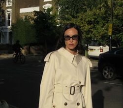 Modelo usa trench coat e óculos de sol na rua