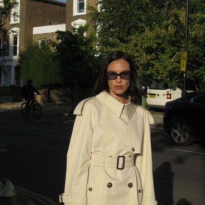 Modelo usa trench coat e óculos de sol na rua