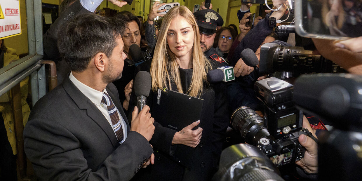 Chiara Ferragni a sair do tribunal após a audiência, rodeada por jornalistas e agentes da polícia Carabinieri, respondendo às perguntas dos jornalistas, ela repete (em italiano): "Tenho fé, não posso dizer mais nada, obrigada."