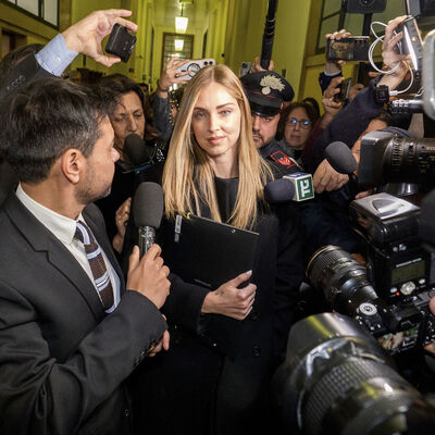 Chiara Ferragni a sair do tribunal após a audiência, rodeada por jornalistas e agentes da polícia Carabinieri, respondendo às perguntas dos jornalistas, ela repete (em italiano): "Tenho fé, não posso dizer mais nada, obrigada."