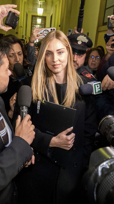 Chiara Ferragni a sair do tribunal após a audiência, rodeada por jornalistas e agentes da polícia Carabinieri, respondendo às perguntas dos jornalistas, ela repete (em italiano): "Tenho fé, não posso dizer mais nada, obrigada."