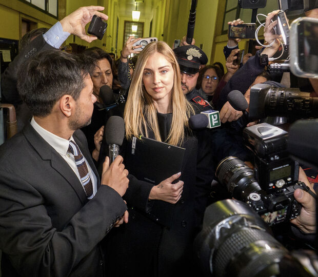 Chiara Ferragni a sair do tribunal após a audiência, rodeada por jornalistas e agentes da polícia Carabinieri, respondendo às perguntas dos jornalistas, ela repete (em italiano): "Tenho fé, não posso dizer mais nada, obrigada."